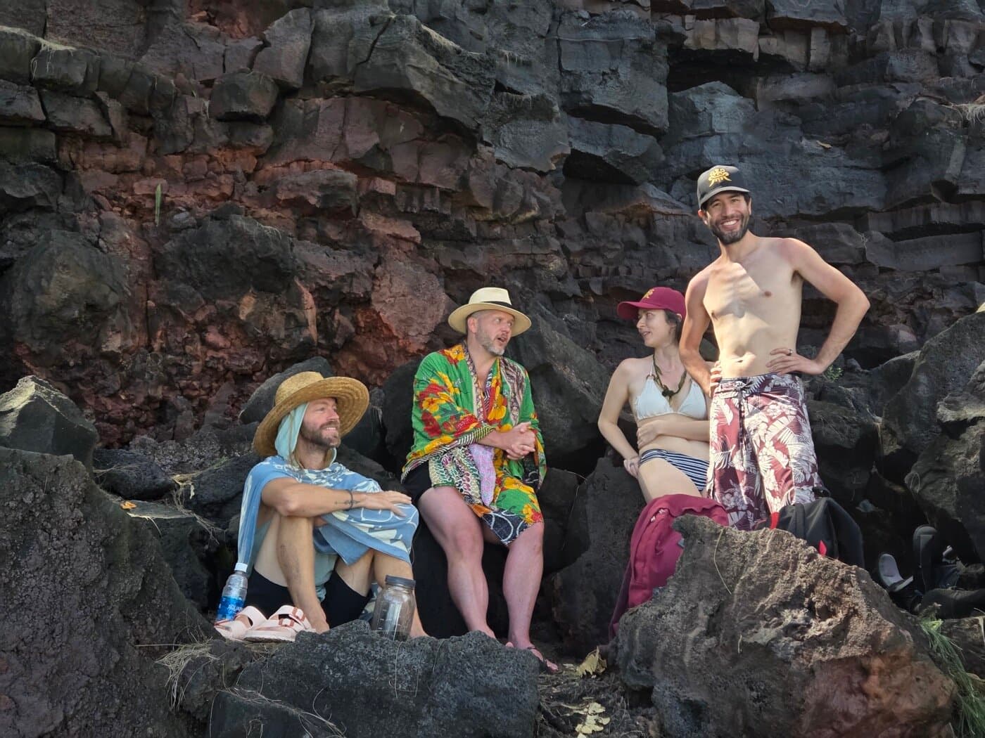 Small group resting on volcanic rocks along the Big Island coast